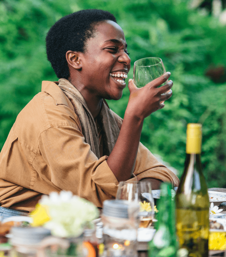 A woman laughing holding a glass of wine